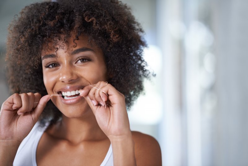 Patient flossing their teeth for better oral care